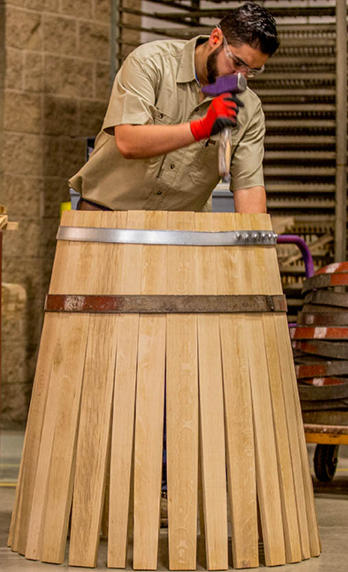 Cooper making a wood wine barrel